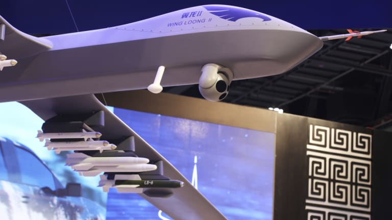 A model of the Wing Loong II weaponised drone hangs above the stand for the China National Aero-Technology Corp at a military drone conference in Abu Dhabi, UAE.